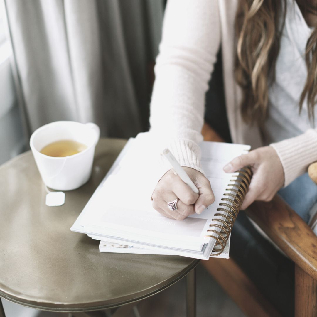 woman writing in her notebook about heart based career planning