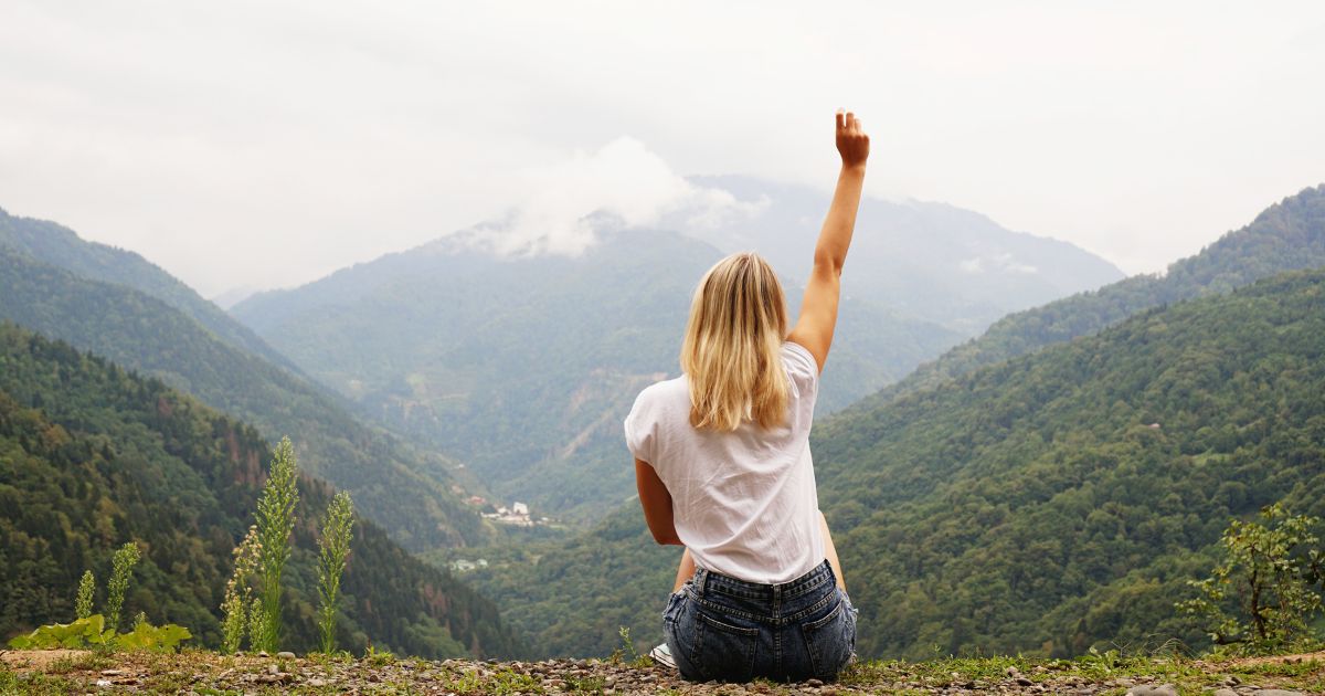 woman looking out over the mountains as she overcomes her self doubt