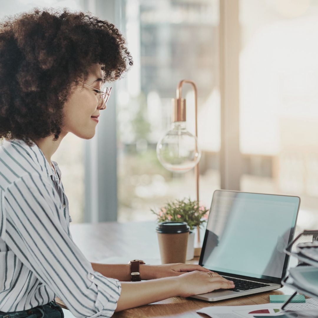 Blog Featured Image Woman sitting at desk working in morning sunshine beside a cup of coffee Flourish Careers